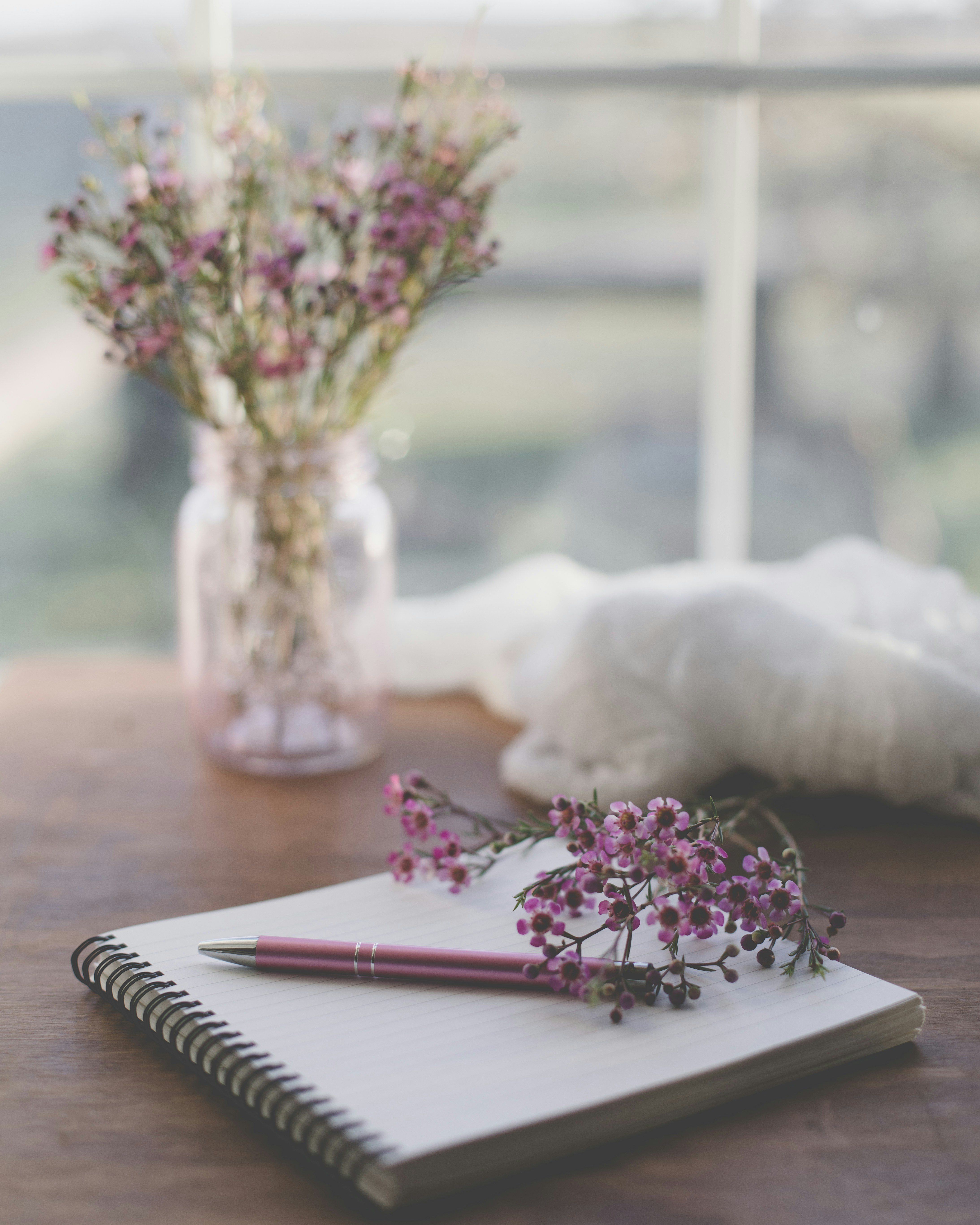 Pregnant woman writing in a journal with a cup of tea beside her